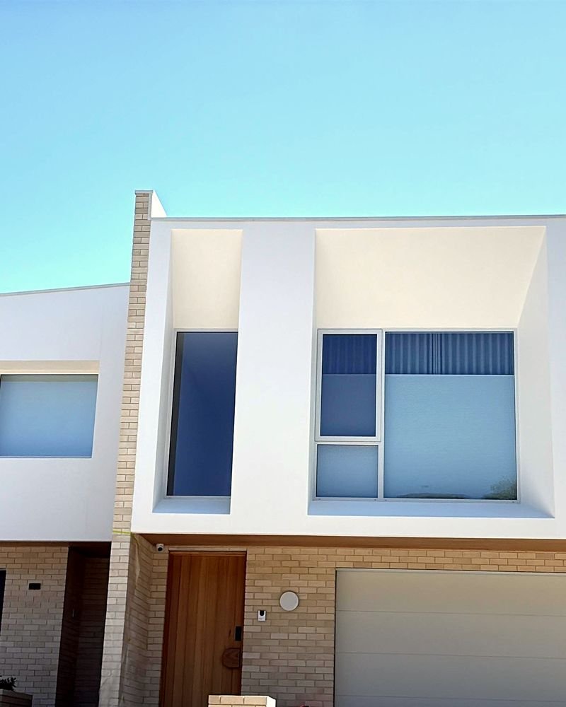 A two-storey Canberra new build with a white rendered facade, finished by AP Sood