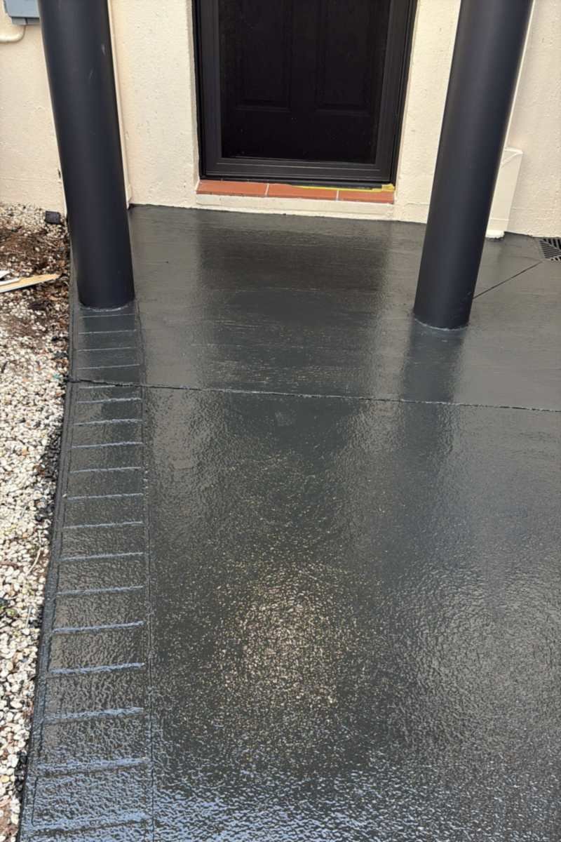 Front porch between two black posts, coated in a glossy charcoal finish