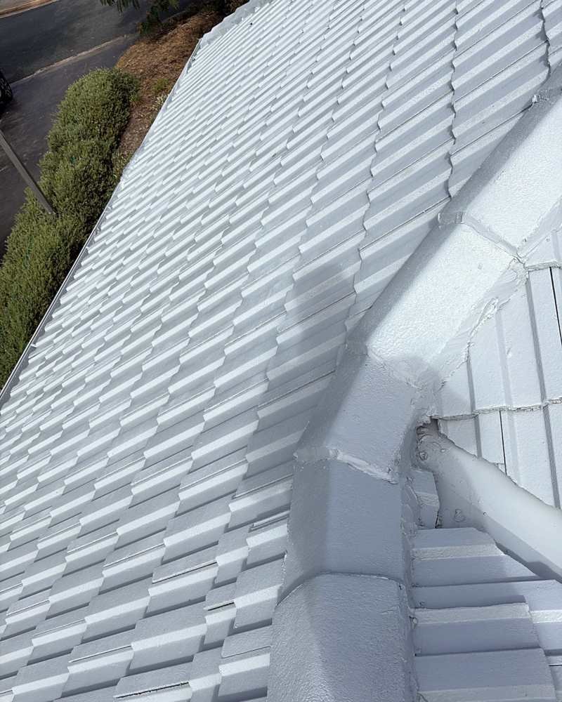 Freshly coated white ridge capping and valley on a tiled roof