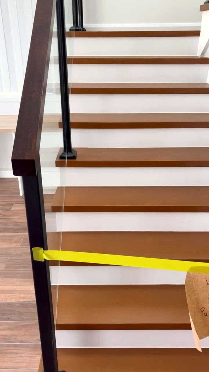 Freshly coated stair treads taped off, with a handwritten note left for the household