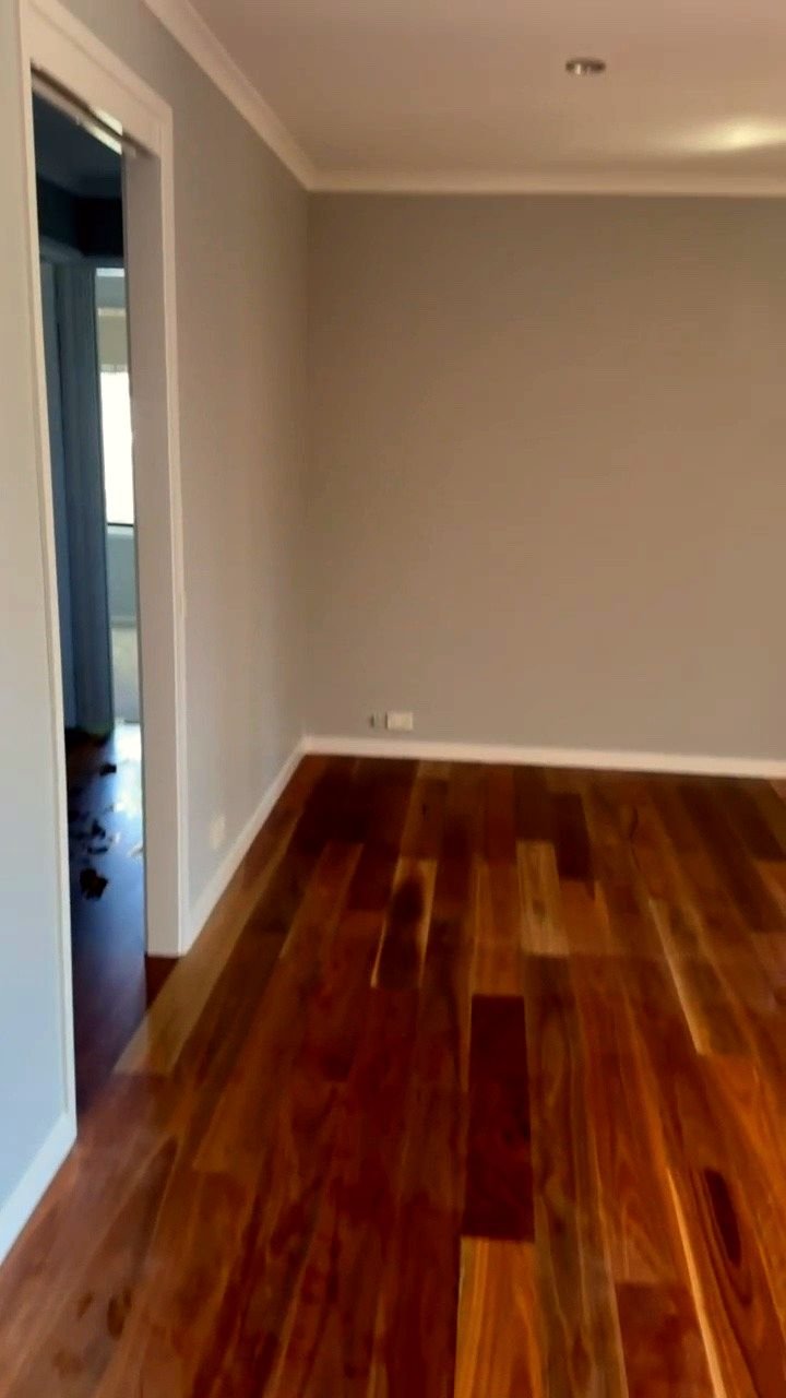Freshly painted room with grey walls, white trims and a polished timber floor